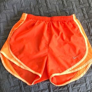 Orange Nike running shorts